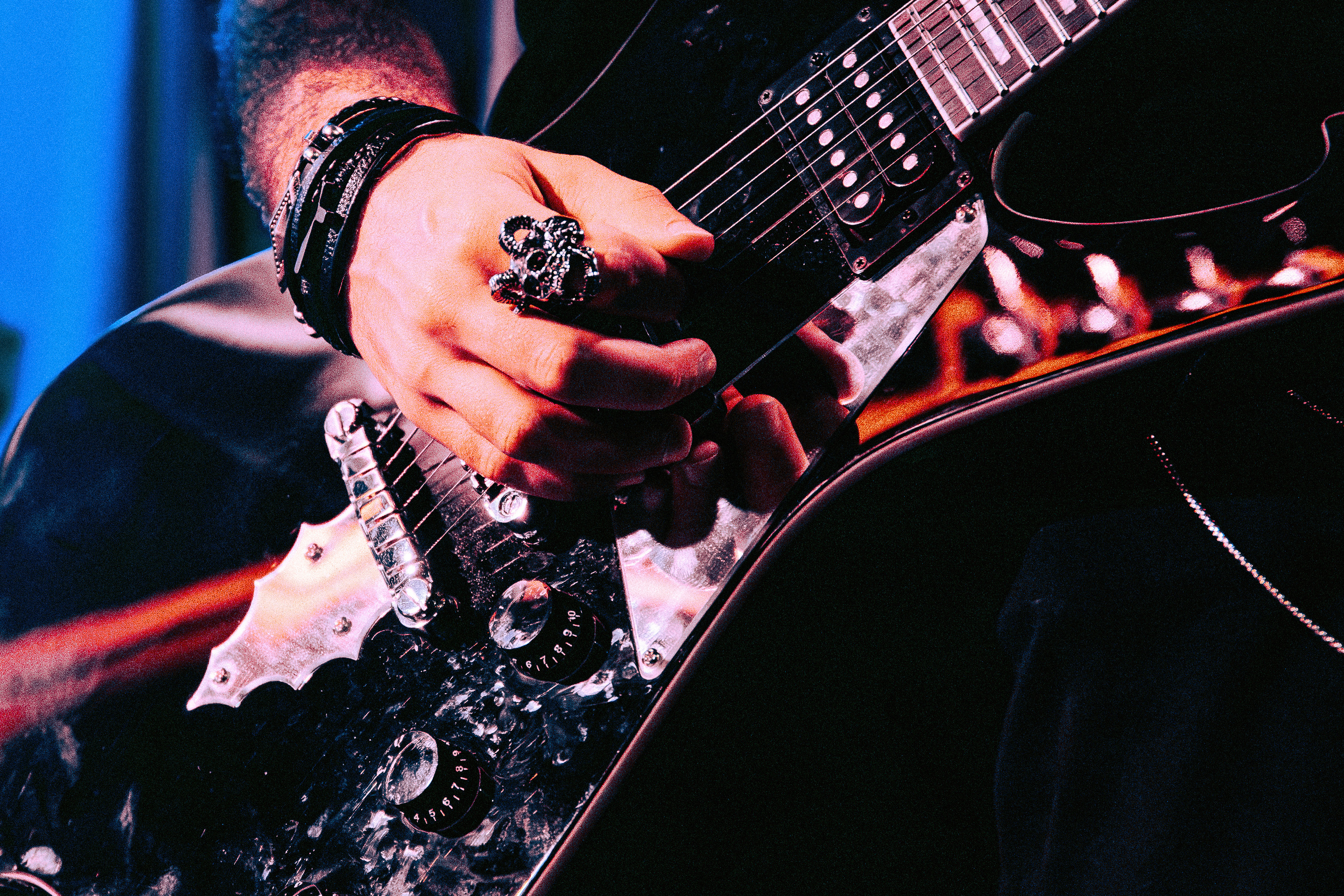 Close-up of a South Coast band member playing electric guitar on stage